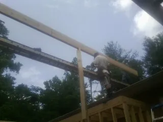 Carpenter setting a ridge beam over a new addition frame — Ice Dam Removal by Roofing Brothers in Careywood