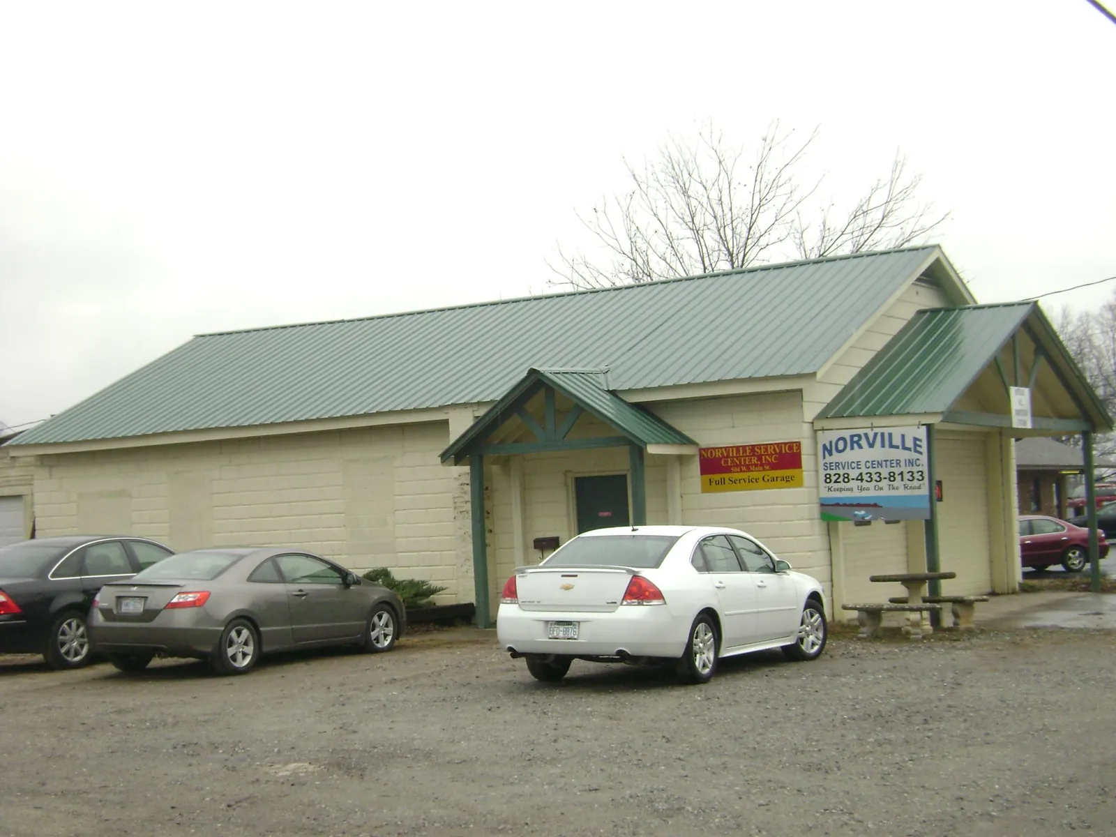 Green metal roof on a service garage with a covered entry in Careywood