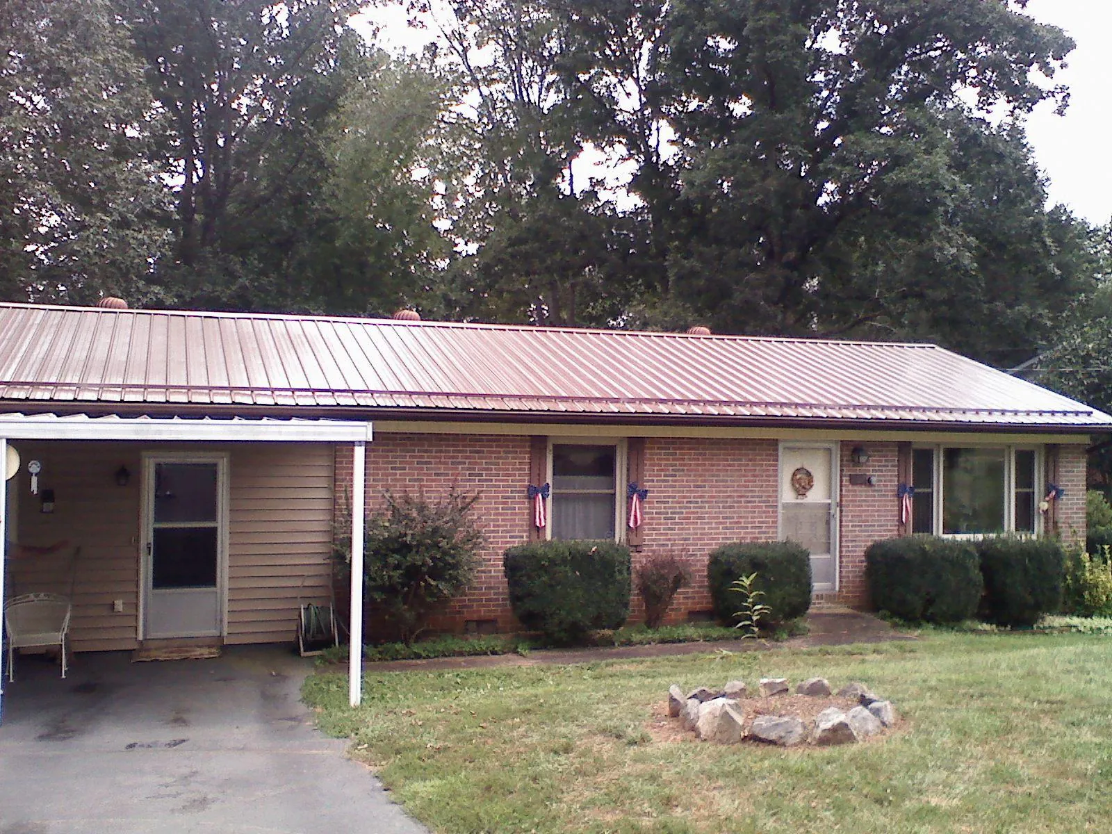 Bronze metal roof and carport on a brick ranch home — Roof Repair work by our crew in Careywood